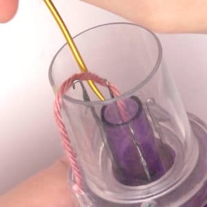 A tapestry needle moving yarn inside the Embellish Knit device.