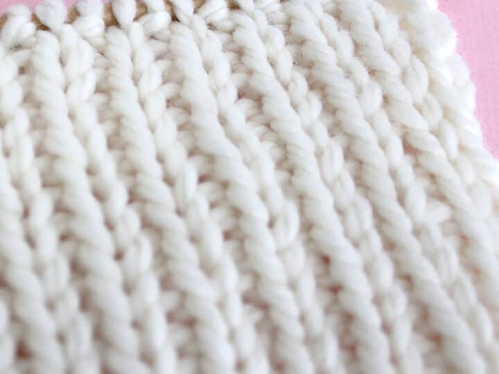 1x1 Rib Knit Stitch Pattern in white color yarn on knitting needle.