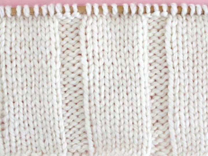 7x3 Rib Knit Stitch Pattern in white yarn on knitting needle.