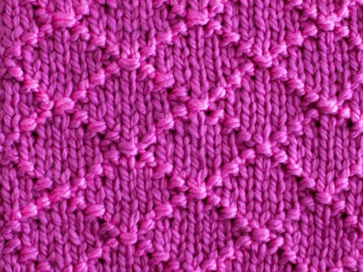 Diamond Brocade Knit Stitch Pattern texture in purple color yarn.