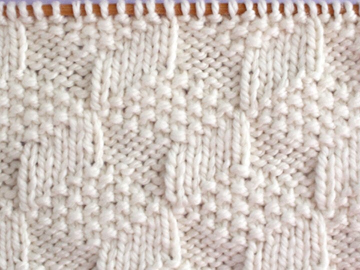 Tumbling Moss Knit Stitch Pattern in white yarn color on knitting needles.