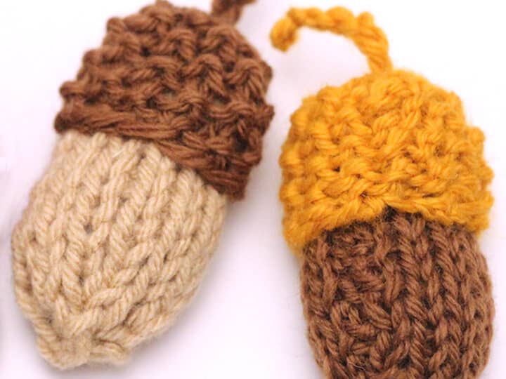 Two knitted acorn softies in brown, yellow, and beige yarn colors on a white background.