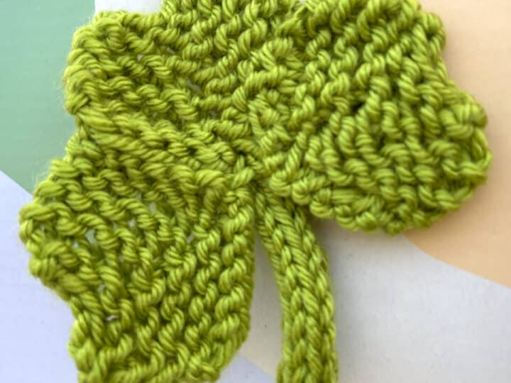 Knitted Shamrock Clover Shape in green color yarn.