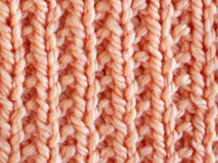 Broken Rib Stitch Knitting Pattern swatch in peach color yarn.