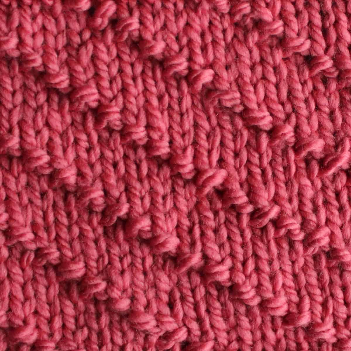 Diagonal Seed Knit Stitch Pattern in pink yarn.