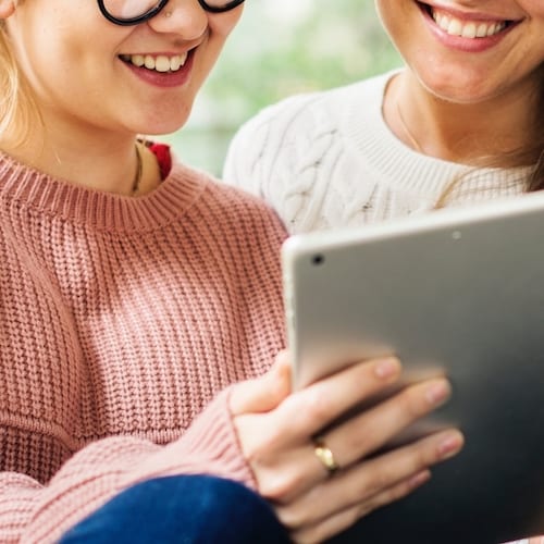 Beginner course with two women looking at a digital tablet.