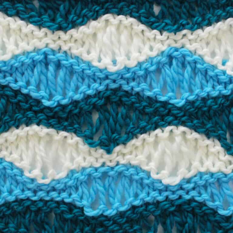 Sea Foam Wave Drop Stitch Knitting Pattern in dark blue, light blue, and white yarn colors.