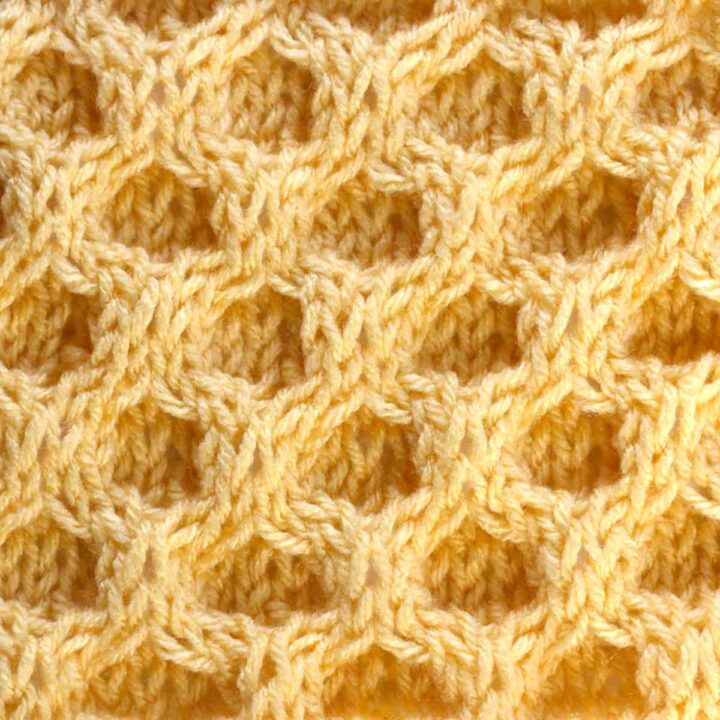 Honeycomb knit stitch pattern in yellow-colored yarn.