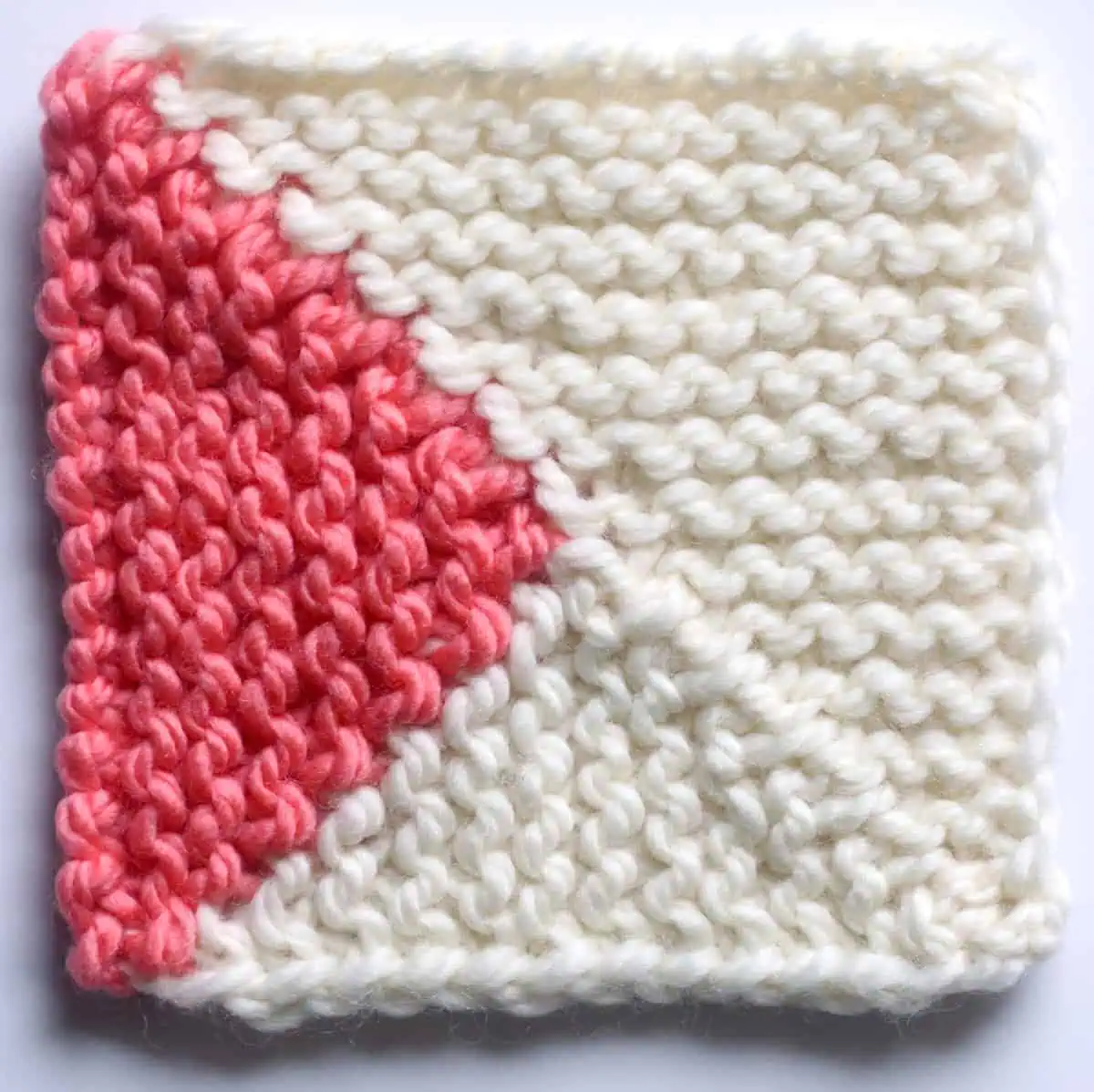 Knitted Mitered Square in Split Quarter Square Triangle Design Pattern with two yarn colors of white and orange.