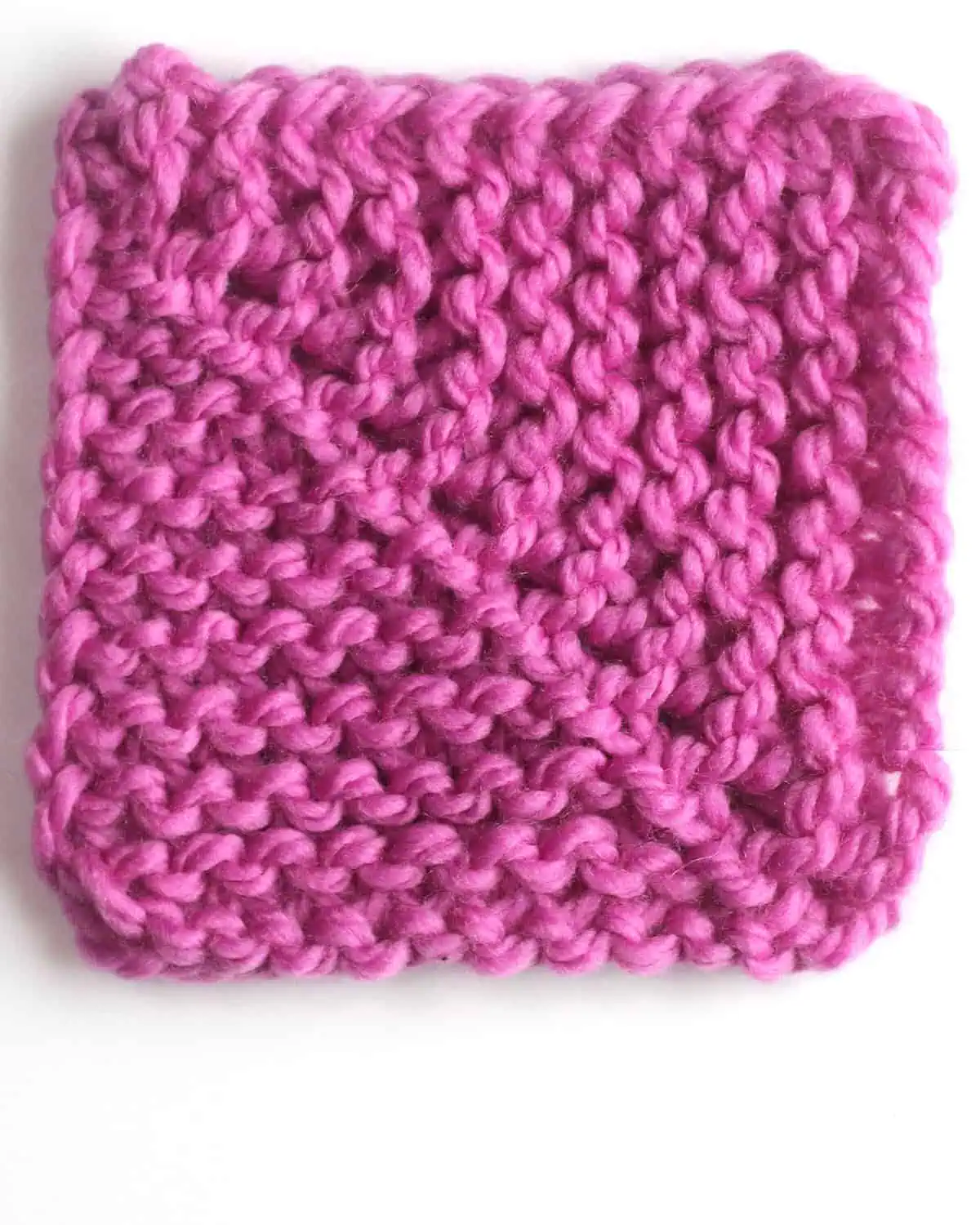 Mitered square knitted with center decreases in purple colored yarn.