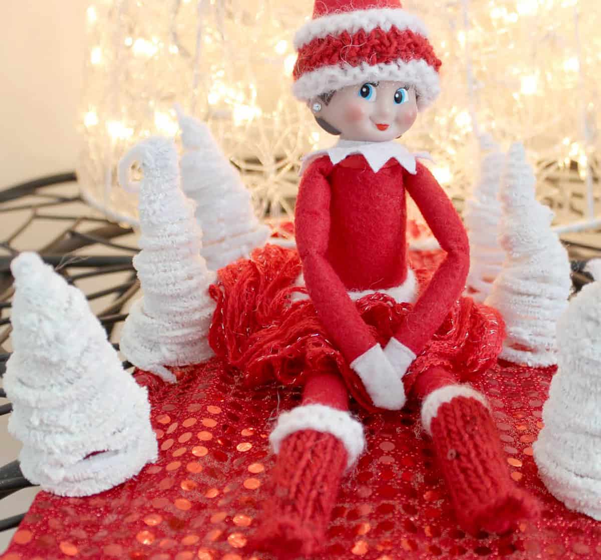 Elf on the Shelf doll wearing a hand knit frilly skirt and boots.