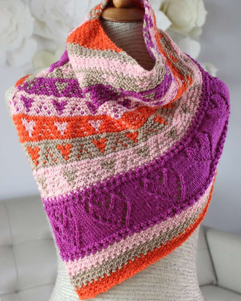 Colorful knitted cowl with lace and slipped stitch hearts displayed on a mannequin.