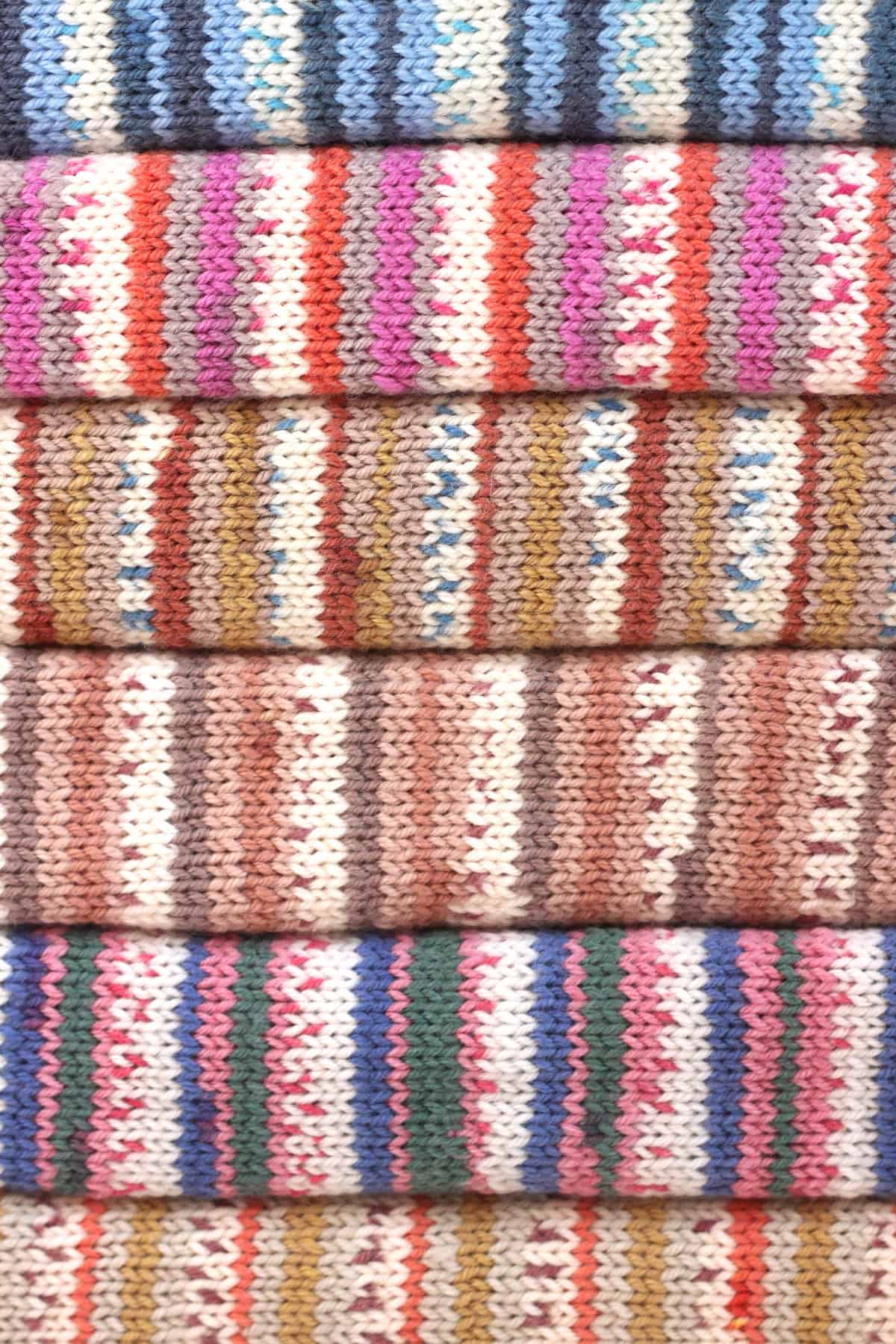 Fairyland Snuggles Baby Blankets in multiple yarn colors stacked atop each other.