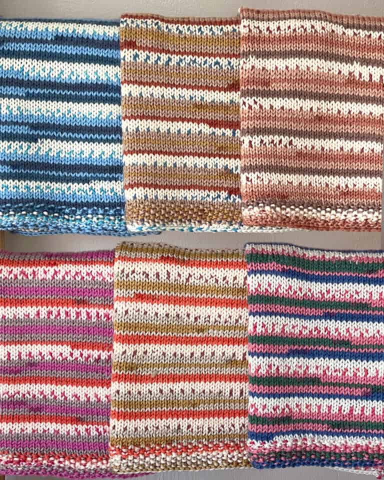 Knitted baby blankets in stockinette stitch hanging on a blanket ladder.